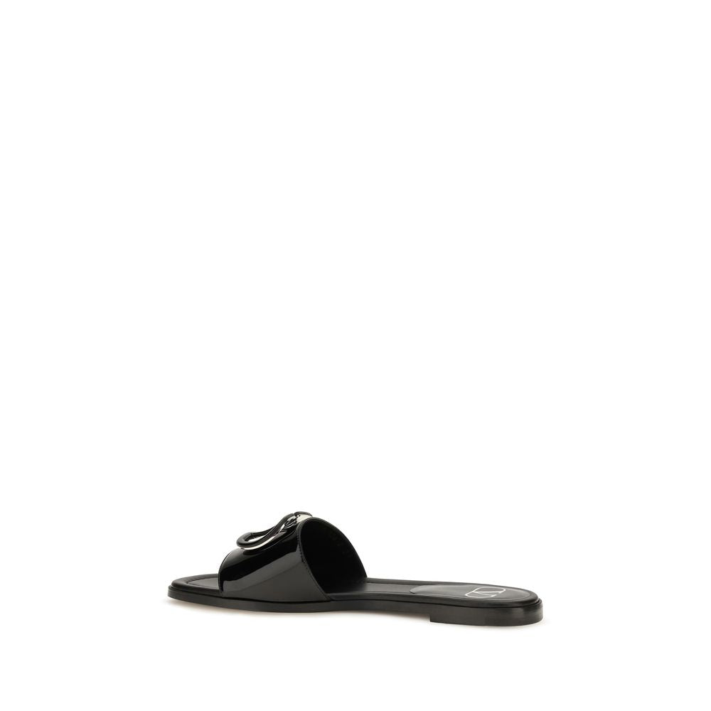Indulge in the exquisite allure of Valentino Garavani's Black Calf Leather Bos Taurus Flat Sandals, where minimalism meets luxury, crafted for the discerning individual.