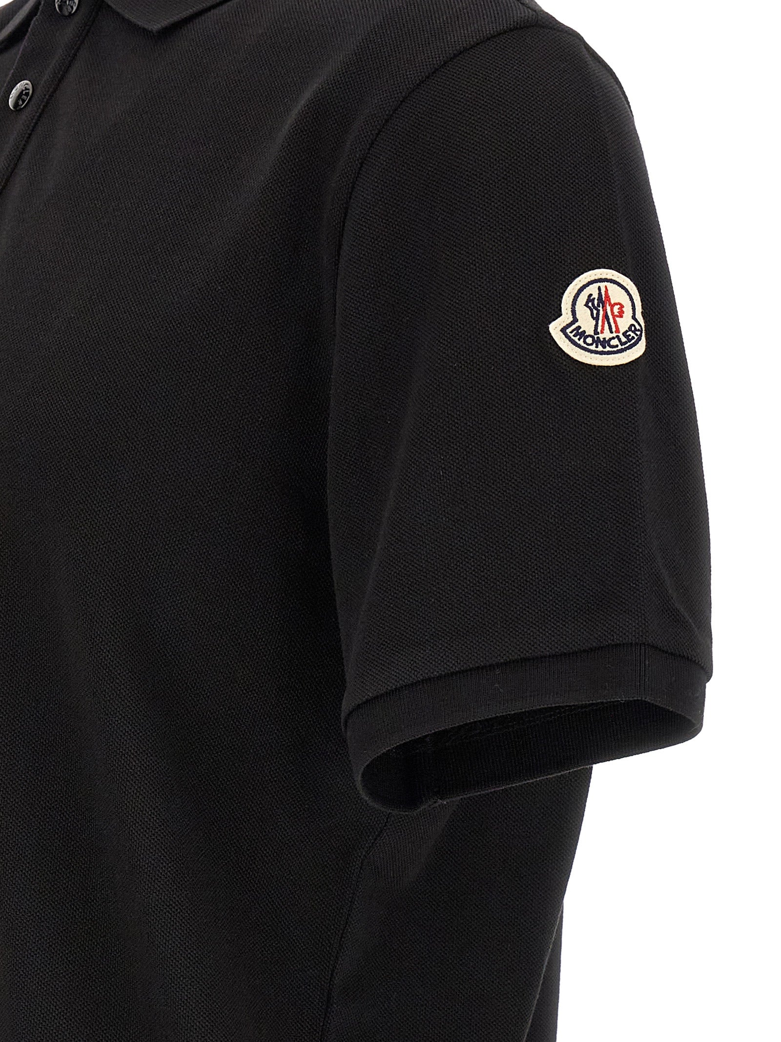Elevate your wardrobe with the Moncler Black Cotton Polo Shirt, a masterpiece of craftsmanship and sophistication that embodies timeless luxury and refined style.