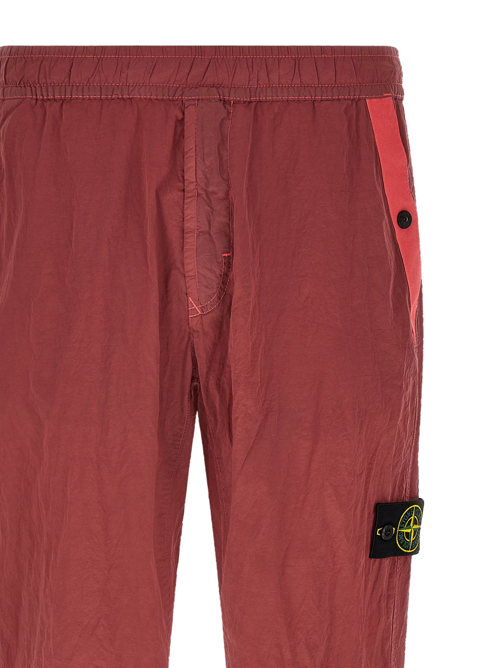 Elevate your urban wardrobe with Stone Island's Red Polyamide Joggers, crafted from innovative Nylon Metal Econyl® for a sophisticated, iridescent finish.