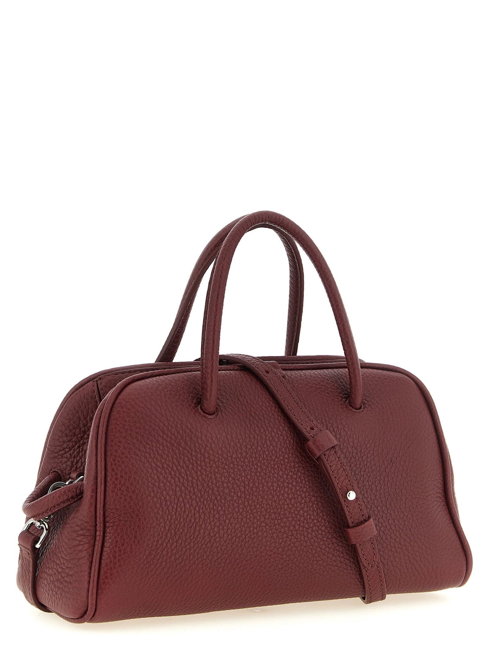 Discover the Jacquemus Le Petit Turismo handbag, a sculptural masterpiece in rich Bordeaux calfskin, redefining elegance and sophistication for the discerning fashion connoisseur.