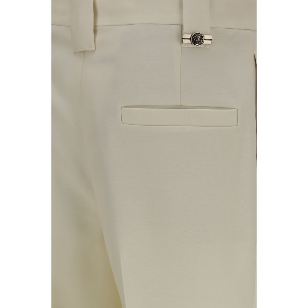 Experience the allure of Versace's Beige Wool Oves Aries Cropped Pants, where tailored elegance meets exquisite craftsmanship, perfect for the discerning fashion connoisseur.