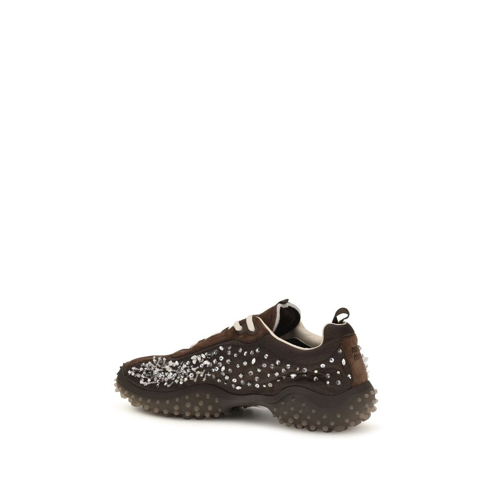 Indulge in the exquisite Miu Miu Brown Suede Leather Sneakers, where luxurious suede meets sparkling crystals, embodying a soft, sporty elegance for the discerning individual.
