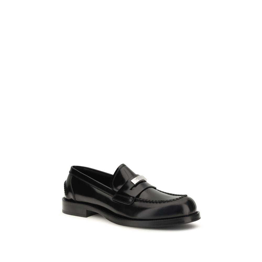 Indulge in the exquisite craftsmanship of Dolce & Gabbana's Black Calf Leather Bos Taurus Slip-On Loafers, a timeless statement of luxury and elegance.
