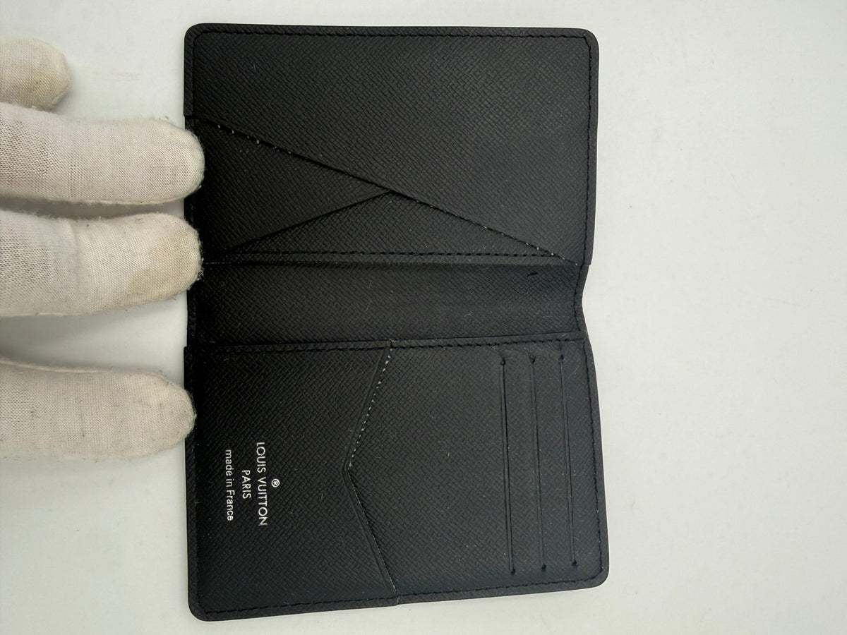 Discover the Louis Vuitton Compatto Card Holder, a masterpiece of Damier Graphite canvas and leather, blending exquisite craftsmanship with timeless elegance for the discerning individual.
