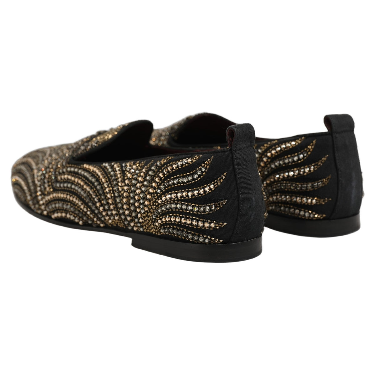 Indulge in the exquisite craftsmanship of Dolce & Gabbana's Black Gold Embellished Slippers, where luxurious leather meets intricate rhinestone artistry, elevating every step with unparalleled elegance.
