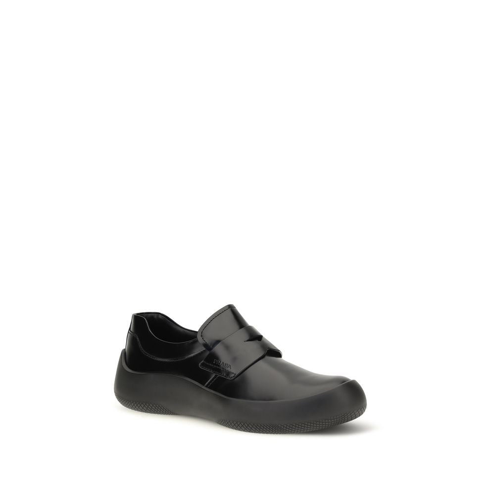 Experience the allure of Prada's Black Calf Leather Bos Taurus Slip-On Loafers, where exquisite craftsmanship meets timeless elegance, perfect for the discerning individual.