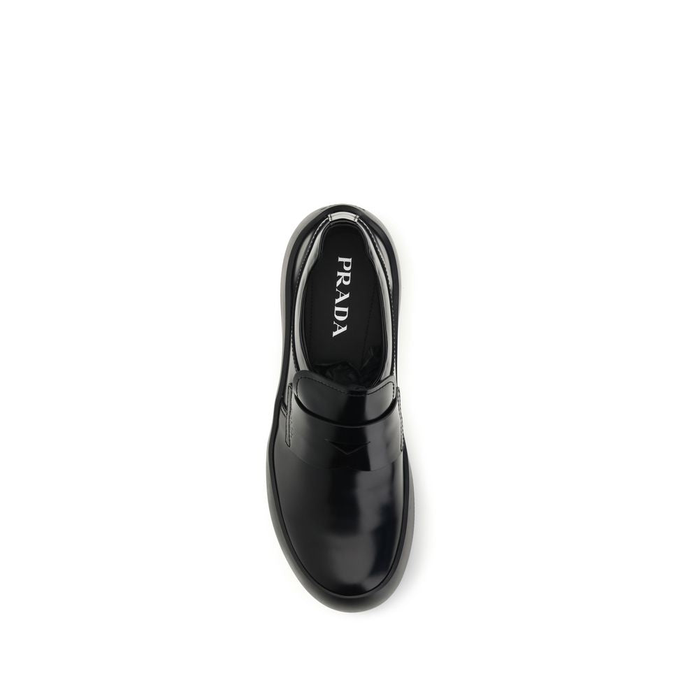 Indulge in the exquisite Prada Black Calf Leather Bos Taurus Slip-On Loafers, where timeless craftsmanship meets modern elegance, elevating your style with every step.