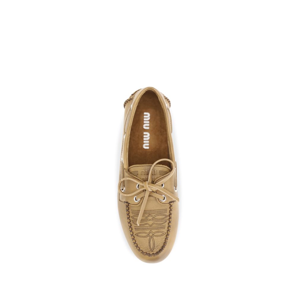Indulge in the exquisite Miu Miu Beige Calf Leather Bos Taurus Slip-On Loafers, where luxurious craftsmanship meets timeless elegance, perfect for the discerning connoisseur.