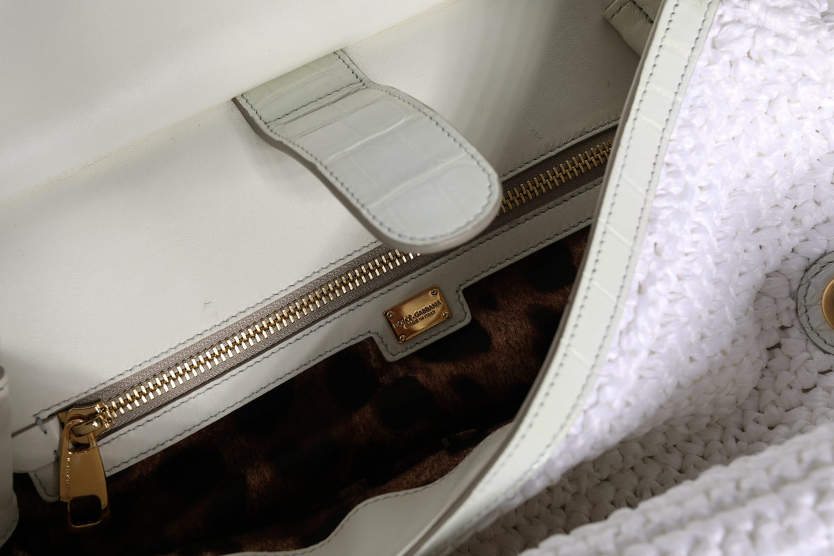 Elevate your style with the Dolce & Gabbana White Rafia Leather Top Handle Crossbody Bag, a masterpiece of Italian craftsmanship blending premium leather and raffia for timeless elegance.