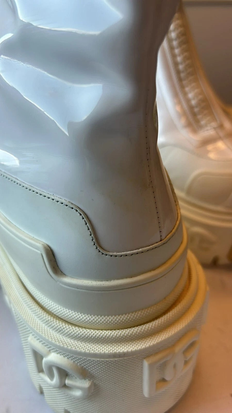 Experience the allure of Dolce & Gabbana's White Leather Rubber Logo Ankle Boots, where exquisite craftsmanship meets timeless elegance for the discerning individual.