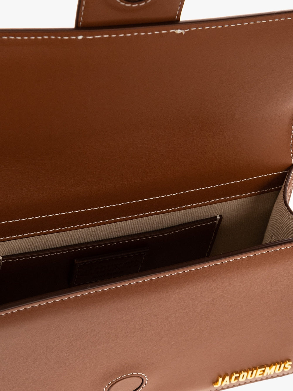 Indulge in the exquisite allure of the Jacquemus Le Grand Bambino light brown bag, a masterpiece of leather craftsmanship that embodies timeless elegance and sophistication.