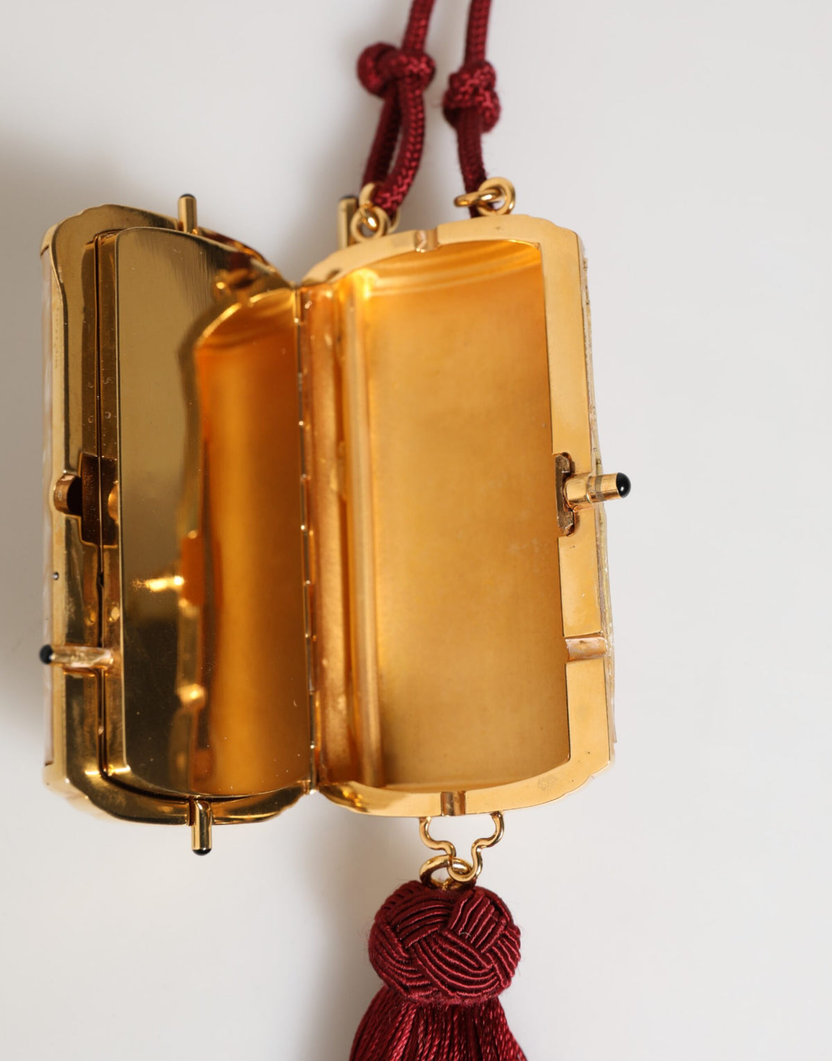 Indulge in the exquisite Dolce & Gabbana White Pearl Resin Gold Metal Red Tassel Pendant Bag, where artisanal luxury meets timeless elegance, perfect for the discerning individual.